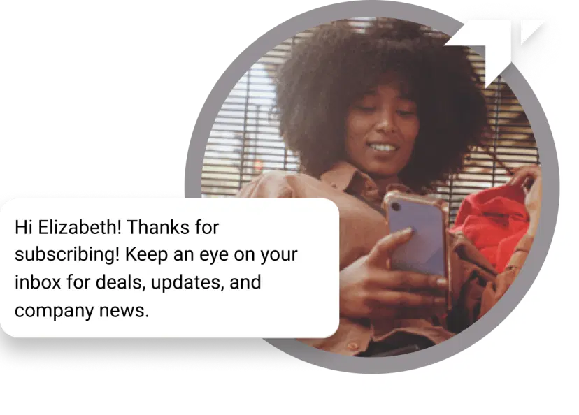 Curly-haired girl sitting on the floor checking her phone for a “Thank You” message received for her subscription
