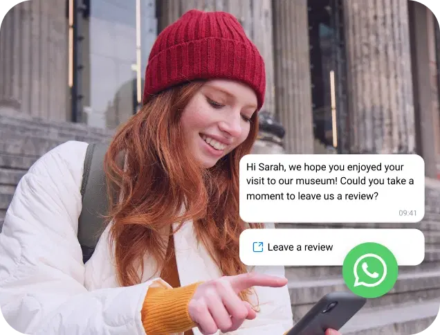 Girl with a red cap reading a WhatsApp business message on her phone