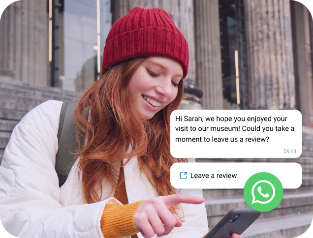 Girl with a red cap reading a WhatsApp business message on her phone